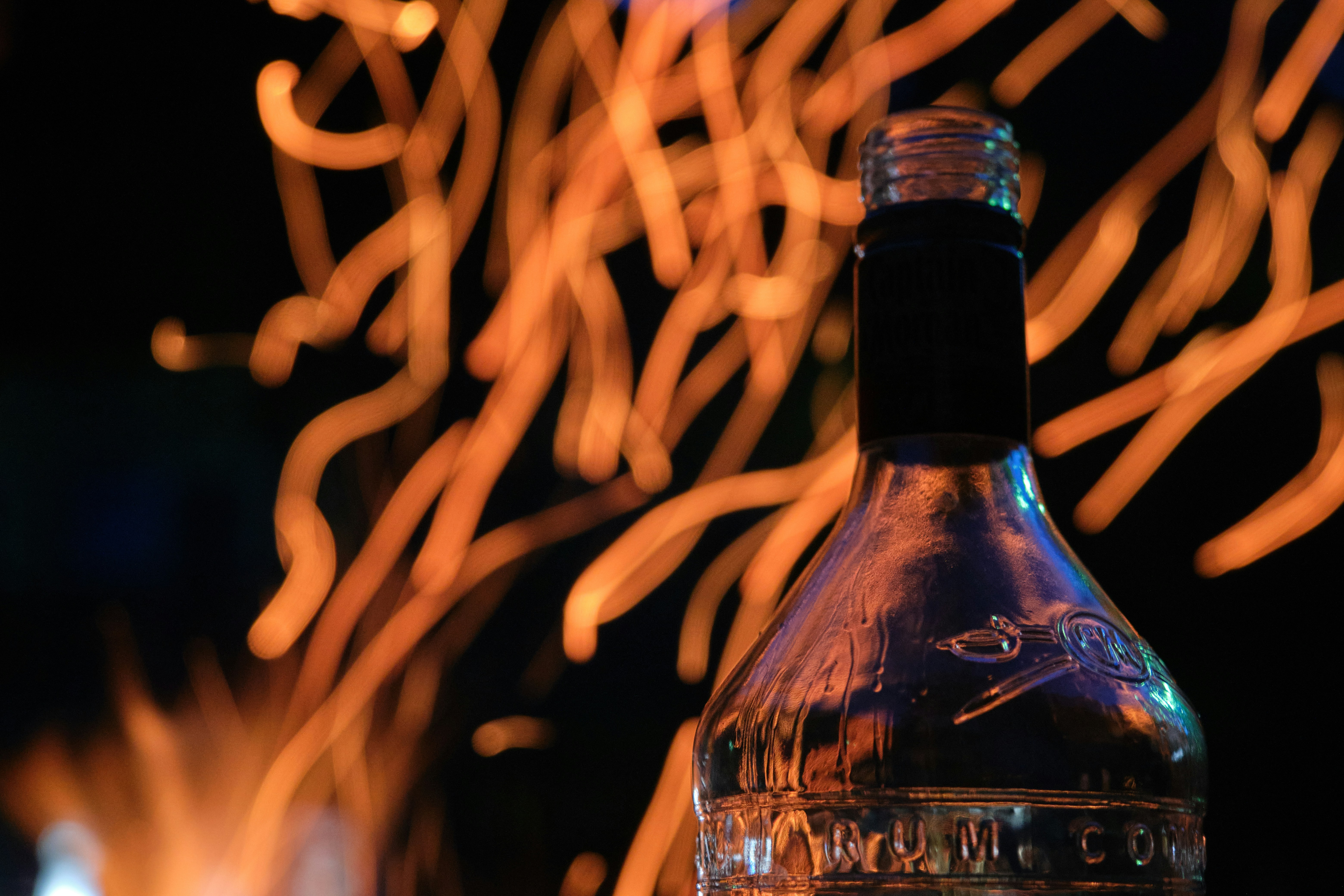 shallow focus photography of black glass bottle