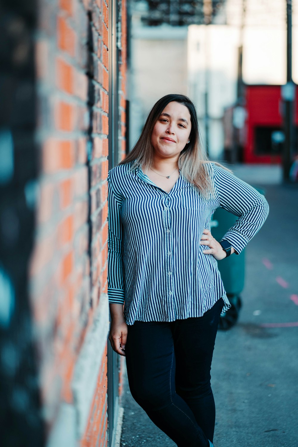 woman in black and white striped long sleeve shirt and black pants standing beside red metal