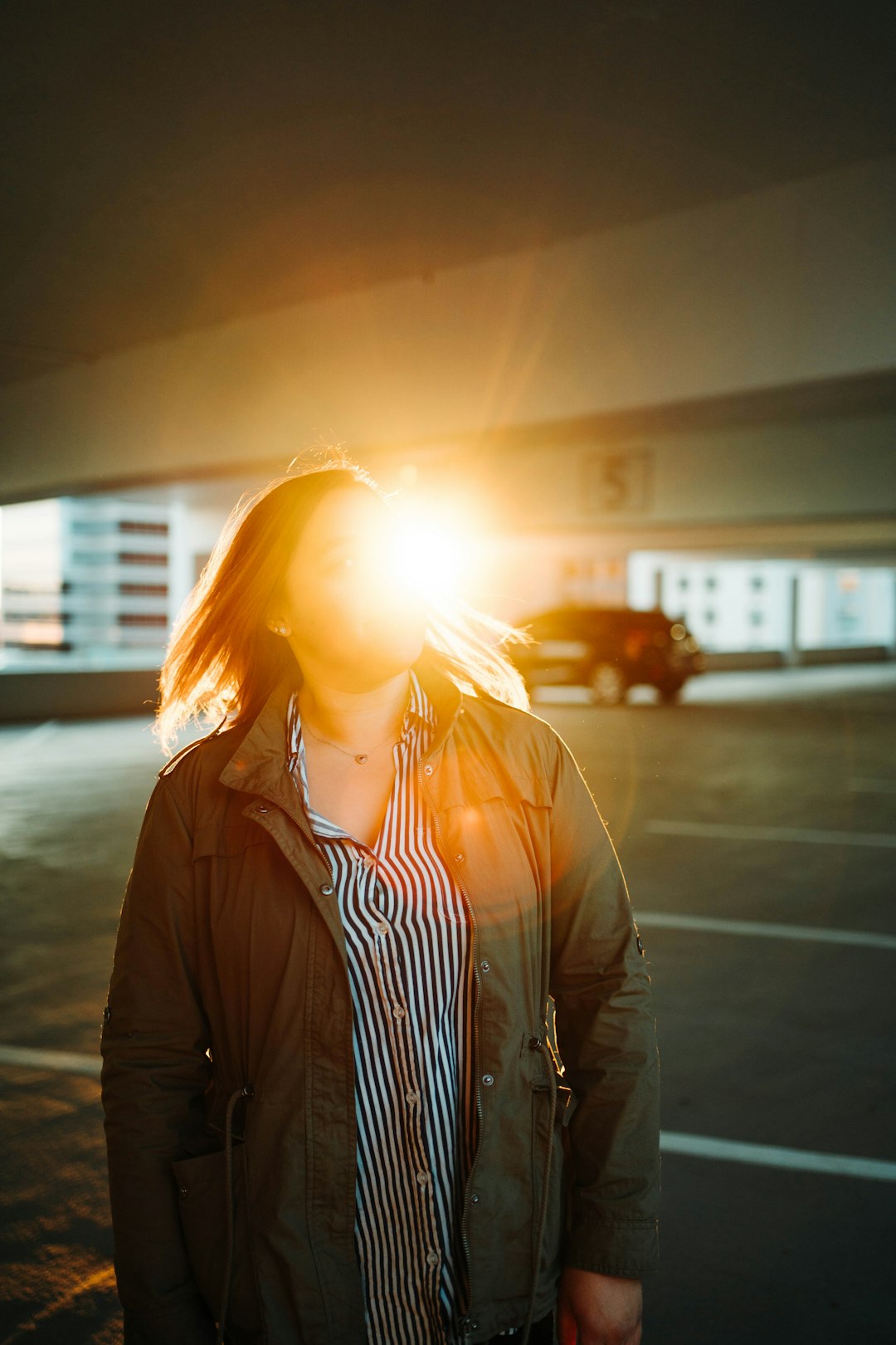 woman in black jacket standing near white building during daytime