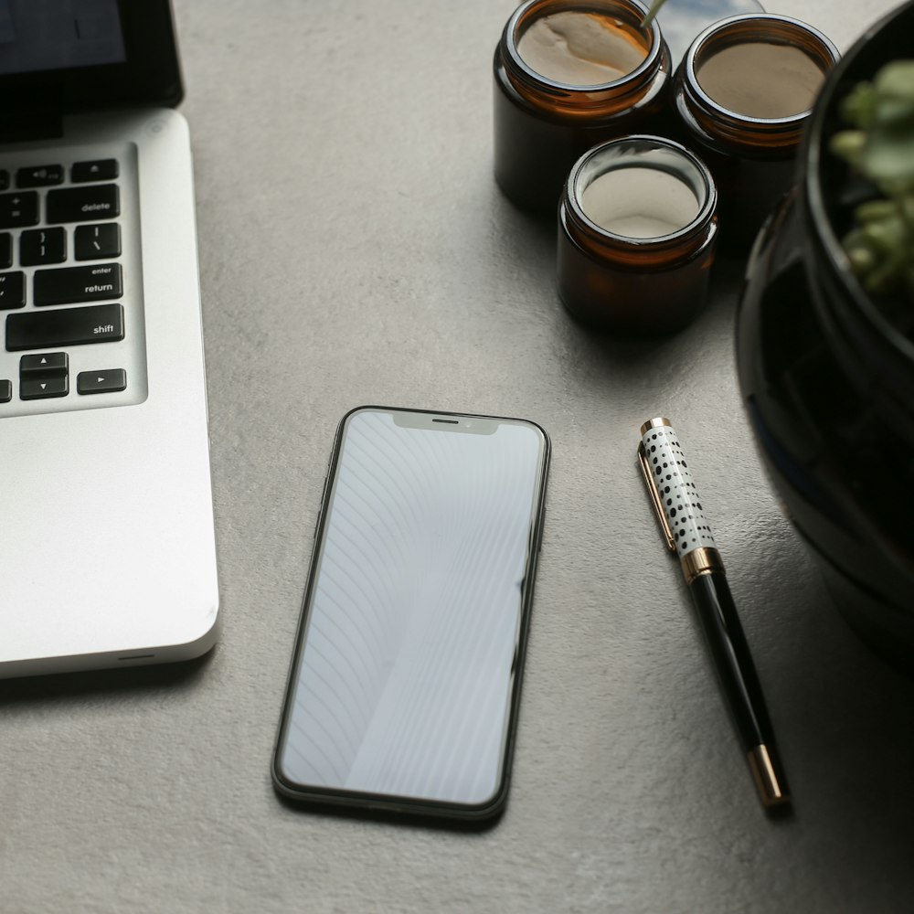 macbook pro beside black and silver pen