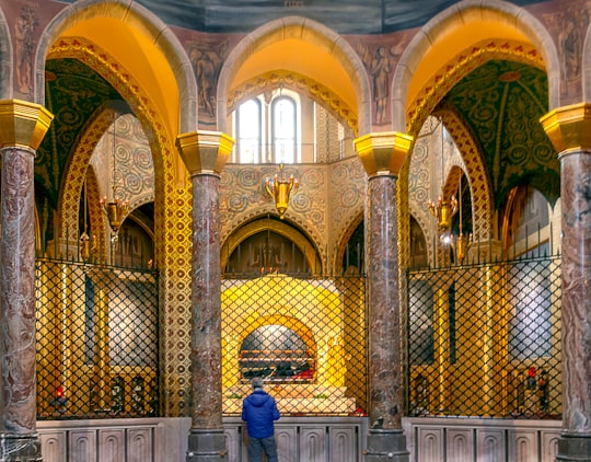 man in blue jacket sitting on bench in Basilica Santa Rita da Cascia Italy