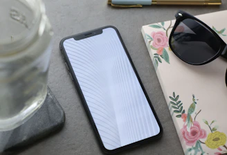 Elegant flat lay of a notebook, gold pen, and smartphone showing social media analytics.