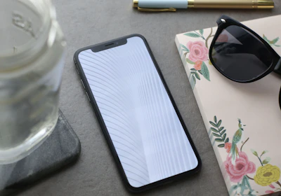 Elegant flat lay of a notebook, gold pen, and smartphone showing social media analytics.
