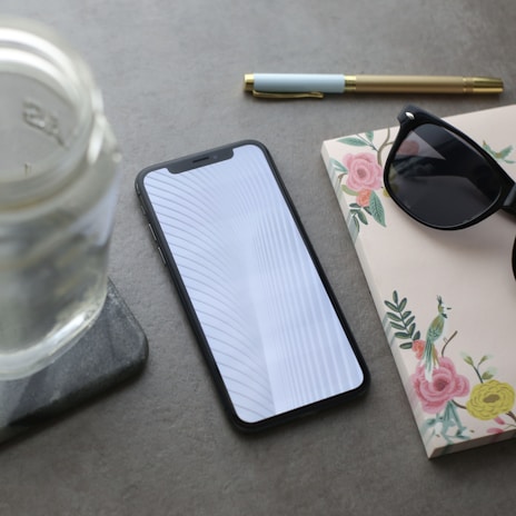 Phone case with a clean, elegant print design placed next to a notebook and pen.