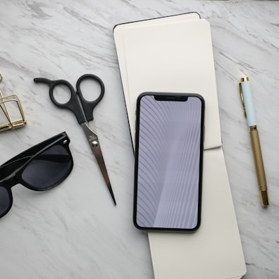 A flat lay of trendy accessories on a marble background.
