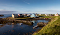 A peaceful island village with colorful houses and boats resting on the shore.