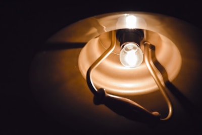 Close-up of a vintage-style light fixture freshly installed by Caloosa Electric, glowing warmly in a sunset-lit room