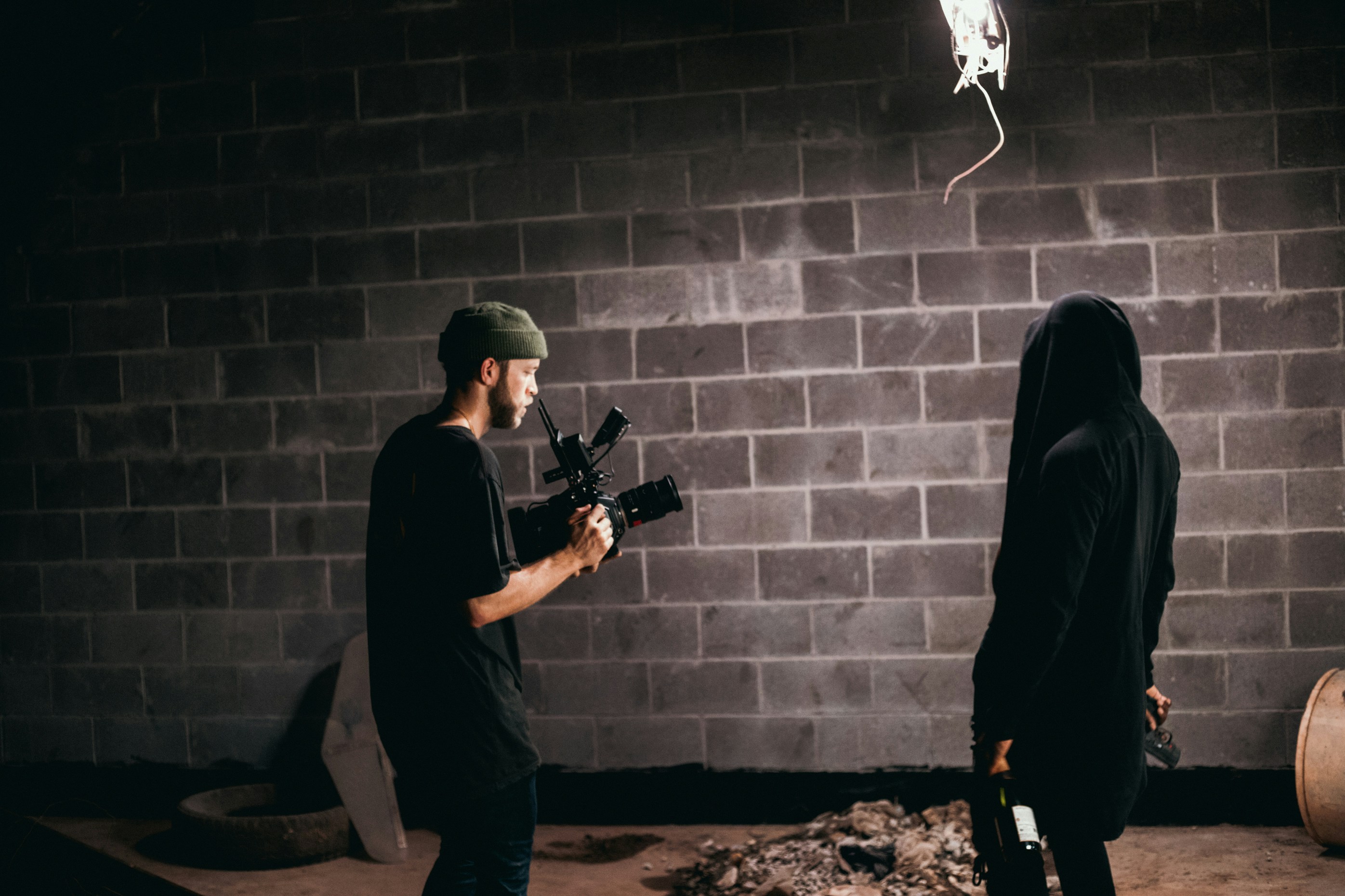 man in black jacket holding black rifle