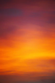 A vibrant sunset gradient blending warm oranges and pinks, ideal for inspirational words.