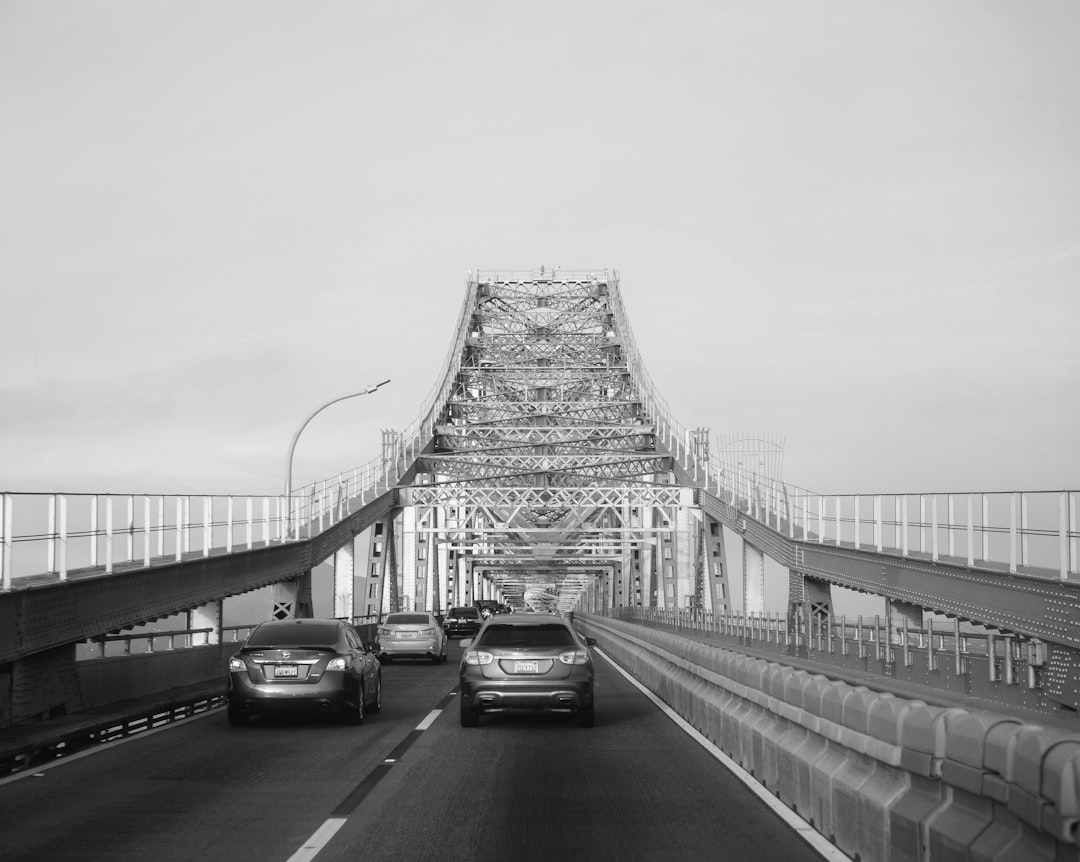 a black and white photo of cars driving on a bridge, Don’t burn your bridges.