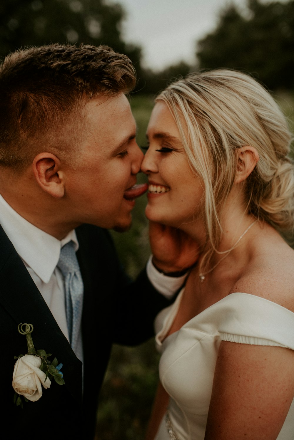 man in black suit kissing woman in white dress