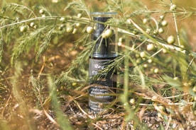 black and gold bottle on brown grass
