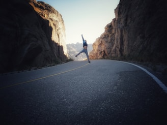 Solo dancer executing a dramatic leap against a backdrop of mountain scenery.