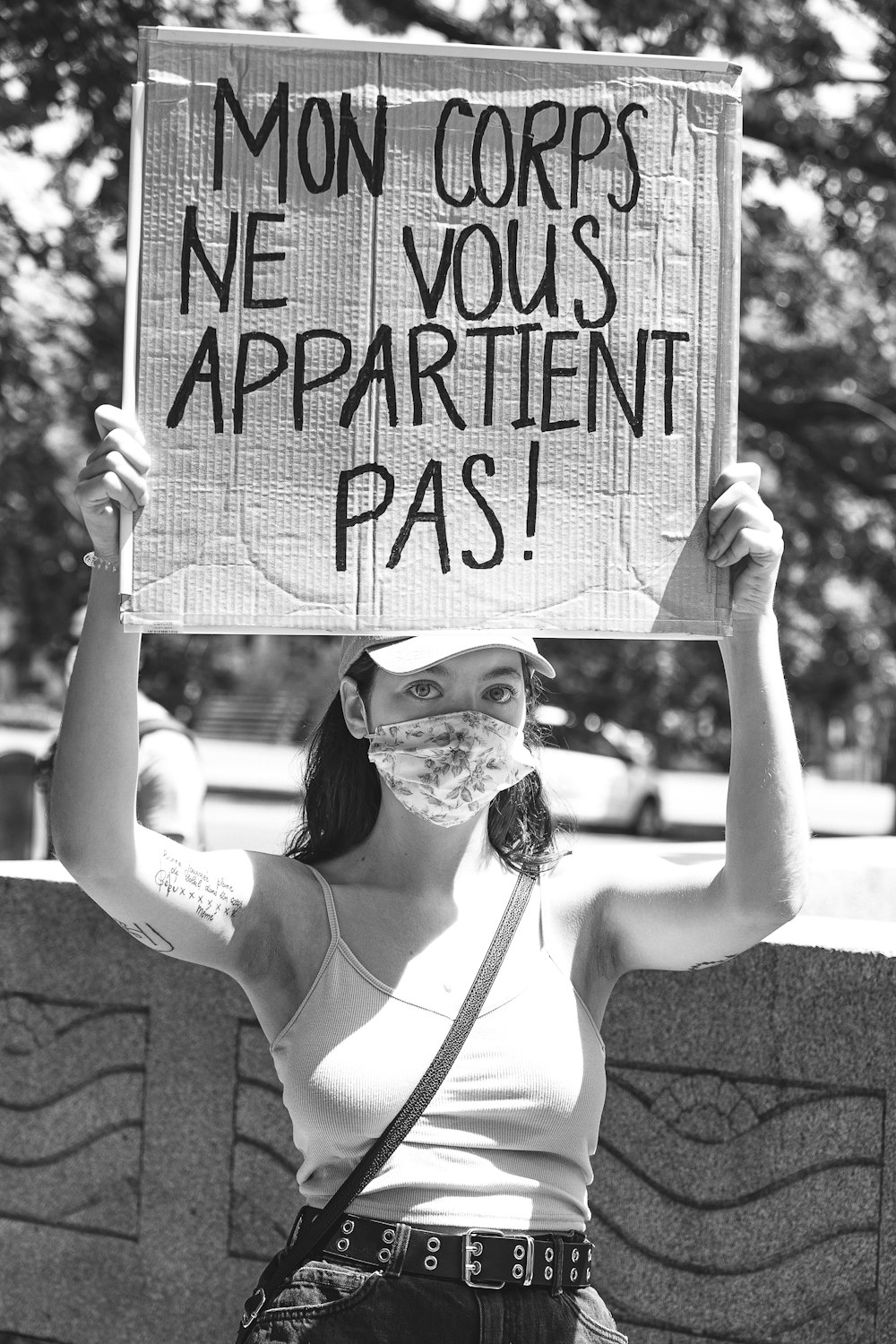 woman in white tank top holding happy birthday signage