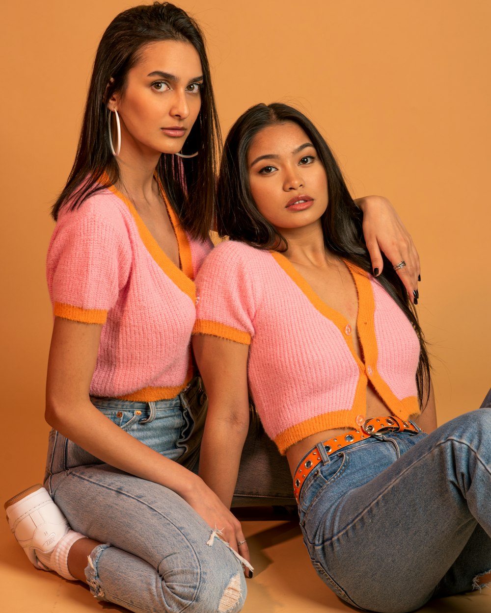 woman in orange and pink striped shirt and blue denim jeans