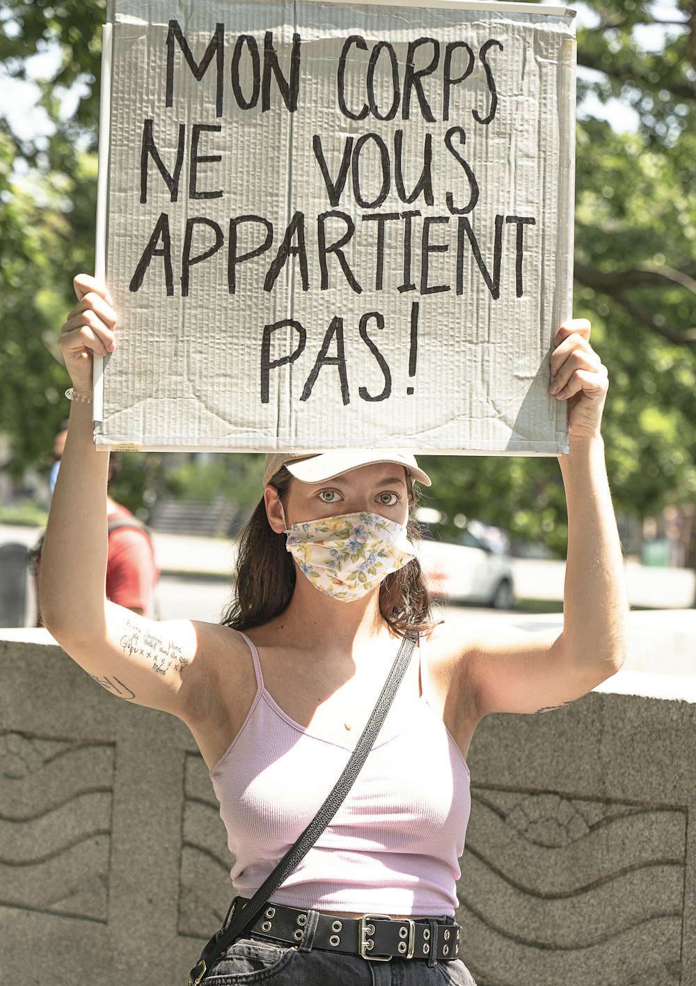 woman in white tank top holding white and black happy birthday signage