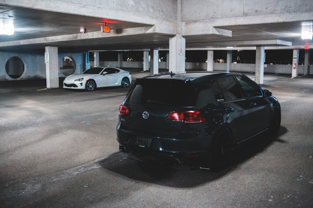 black sedan parked in front of white car