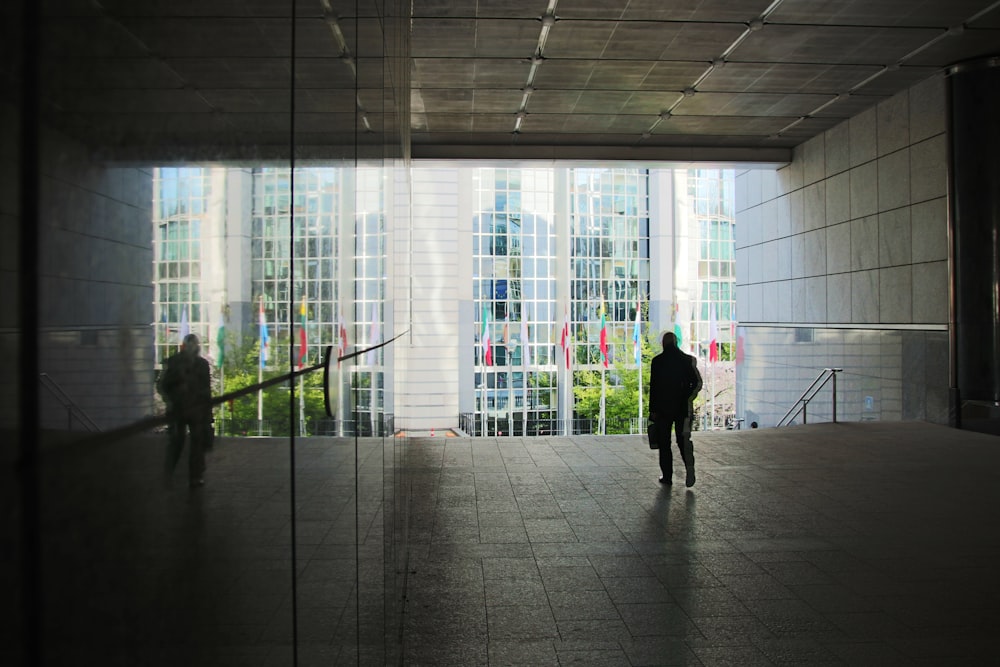 silhouette of 2 person walking on hallway