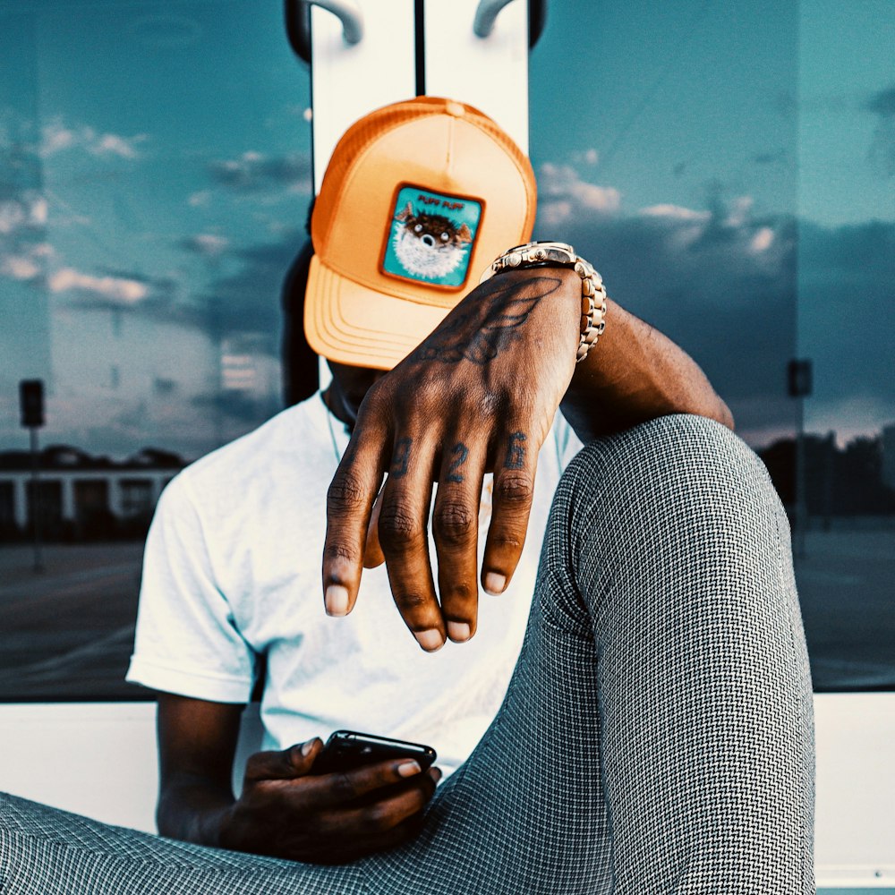 a man wearing a hat and a cell phone