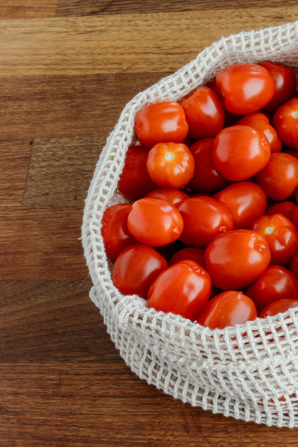 red tomato on white woven basket