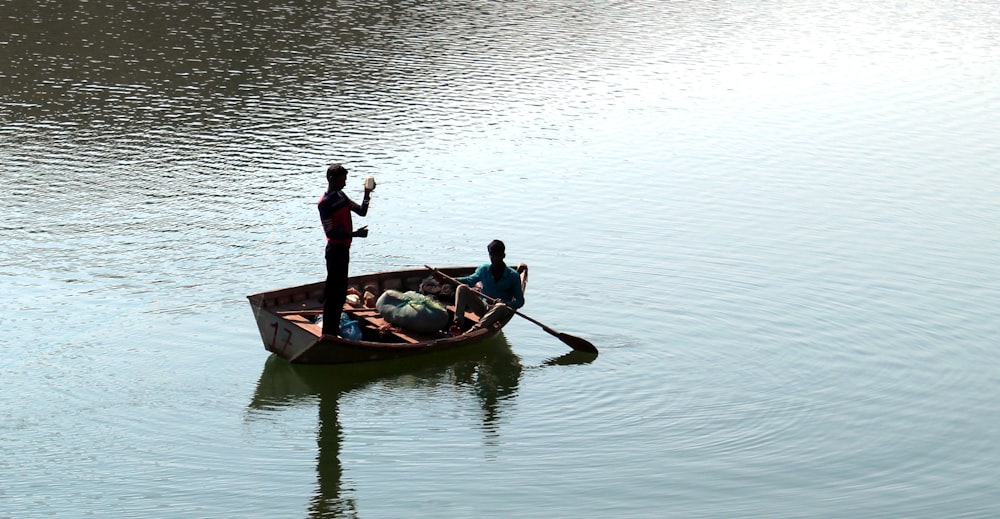 man and woman riding on green boat on body of water during daytime