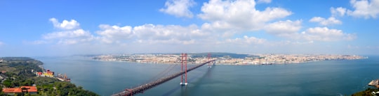 red bridge over body of water during daytime in Almada Portugal