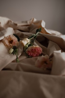 A soft bouquet of lavender and blush pink flowers resting on a light ivory linen cloth.