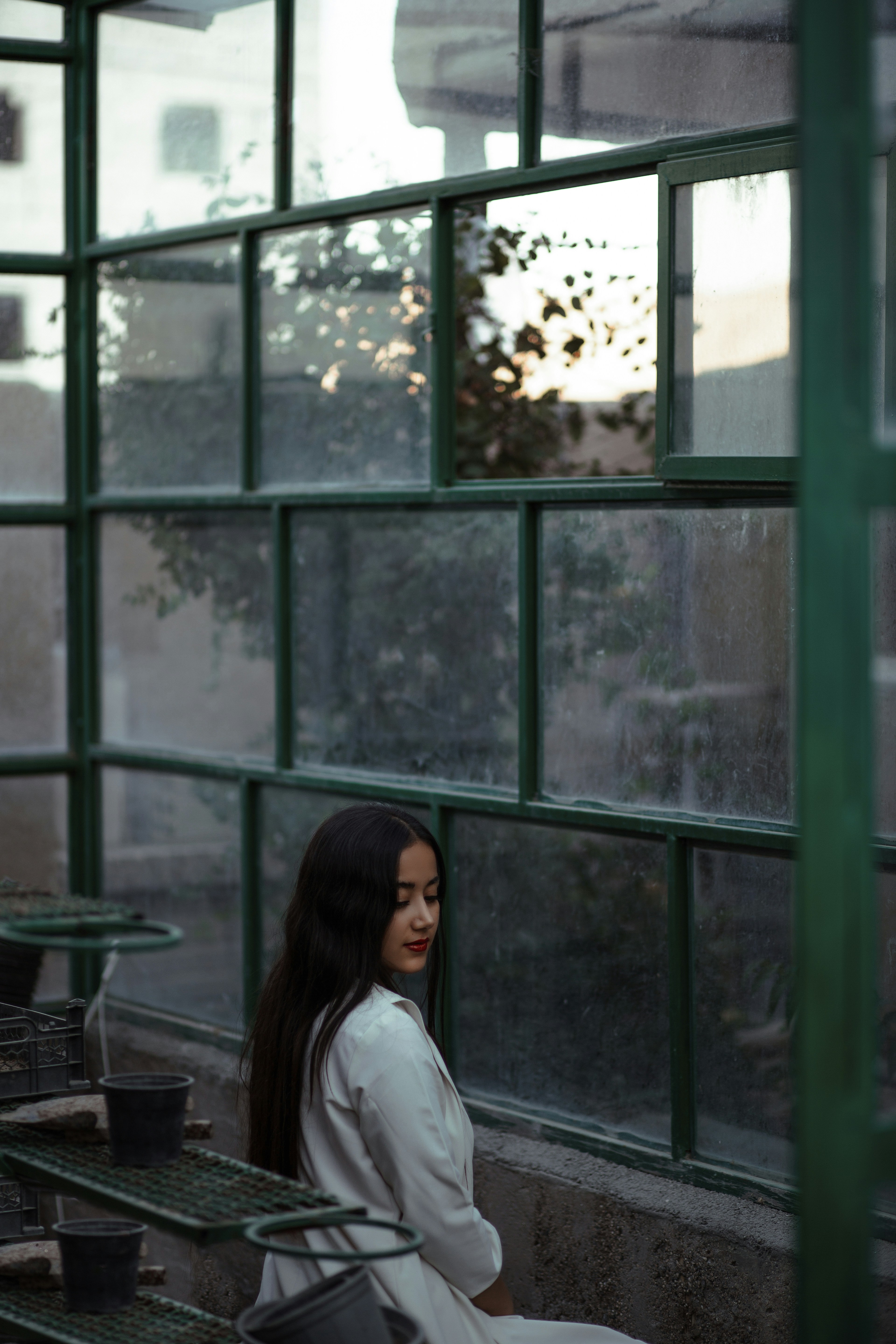 woman in white shirt standing near window