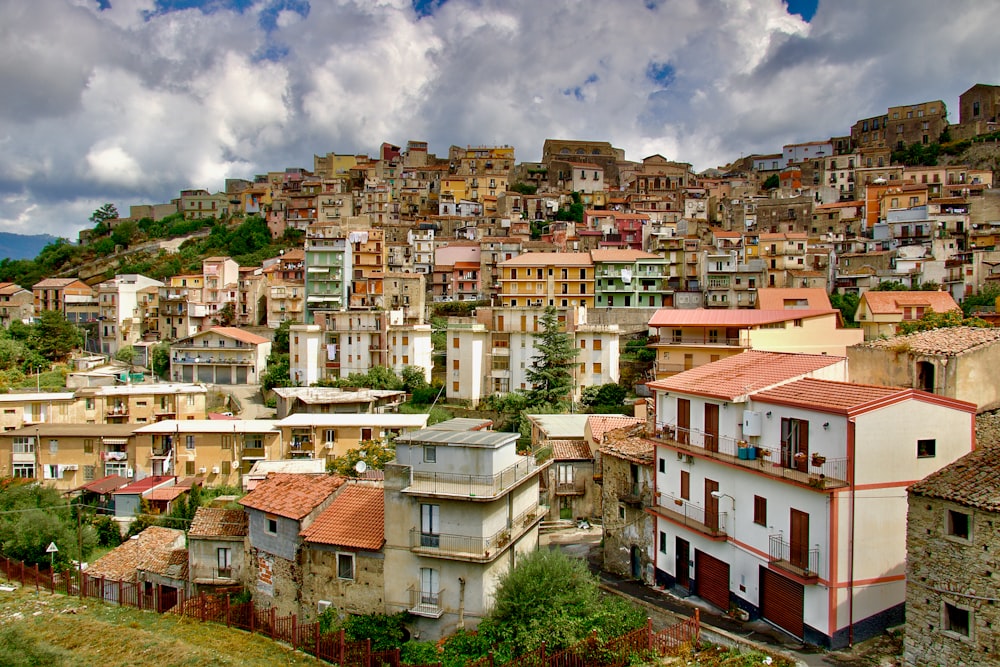 white and brown concrete houses under white clouds and blue sky during daytime