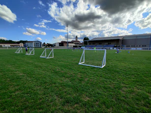 white metal frame on green grass field under blue sky during daytime