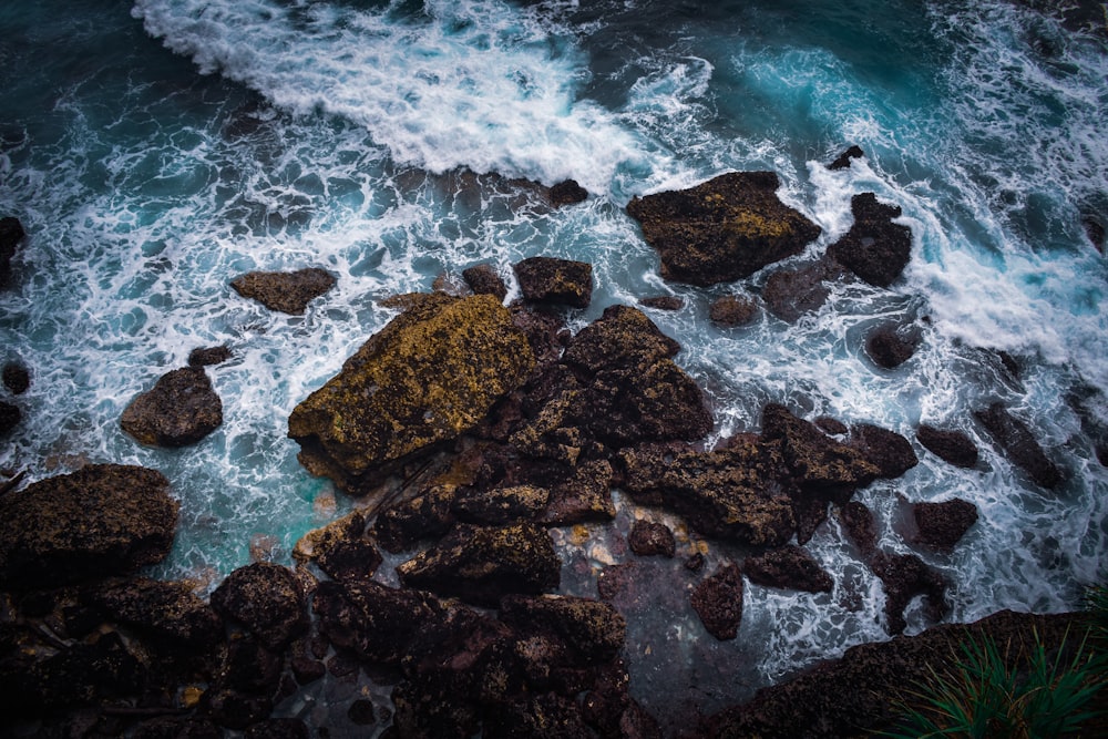 brown rocks on body of water during daytime