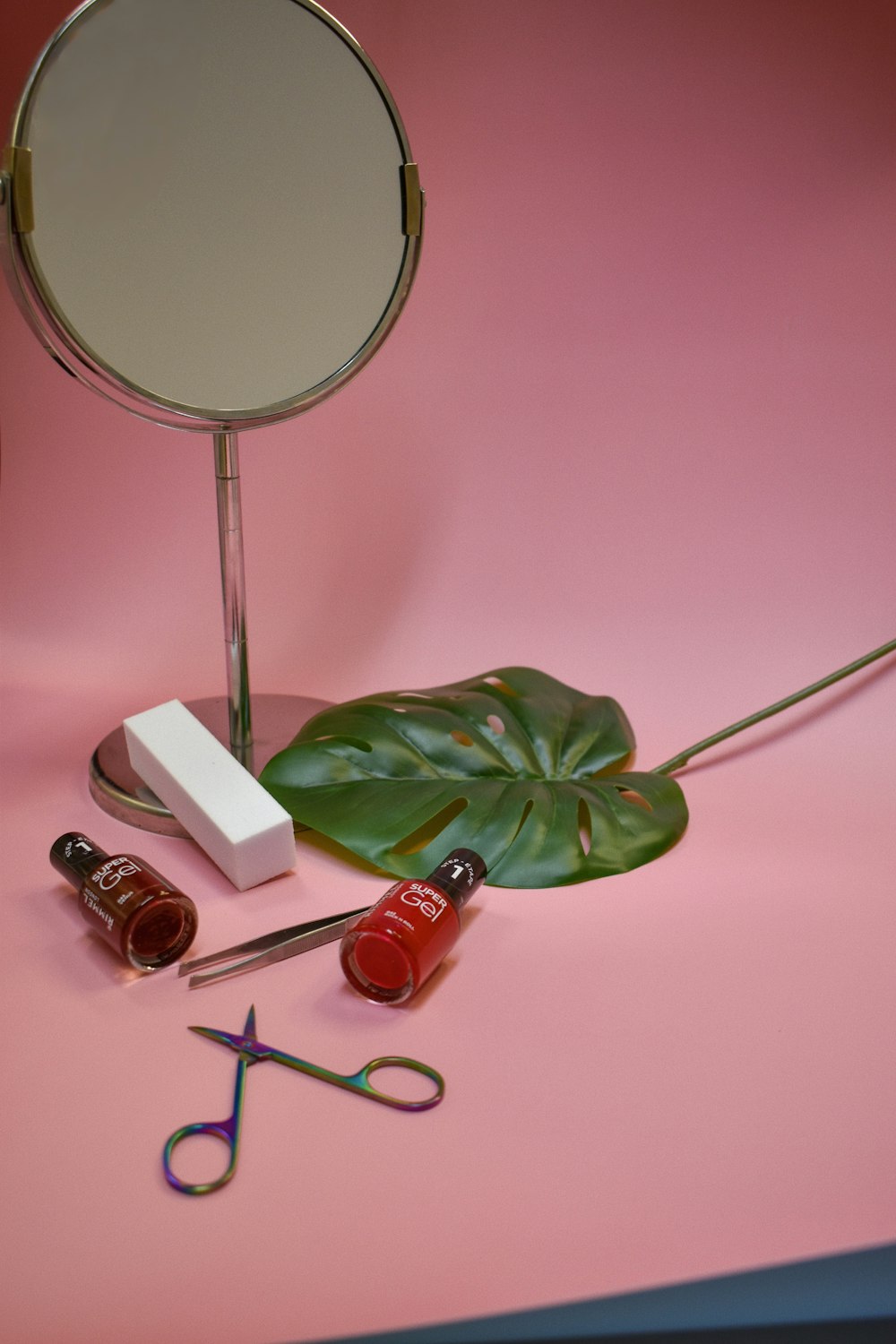 silver framed magnifying glass beside green plant