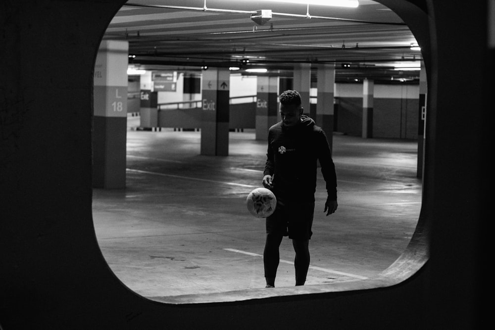 grayscale photo of man playing soccer