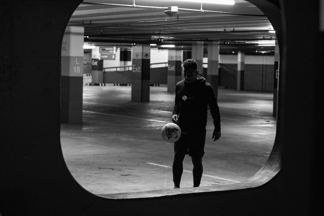 grayscale photo of man playing soccer