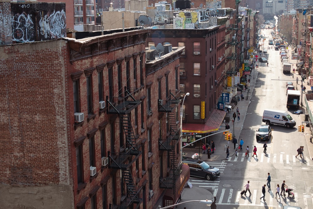 cars parked on street in between high rise buildings during daytime