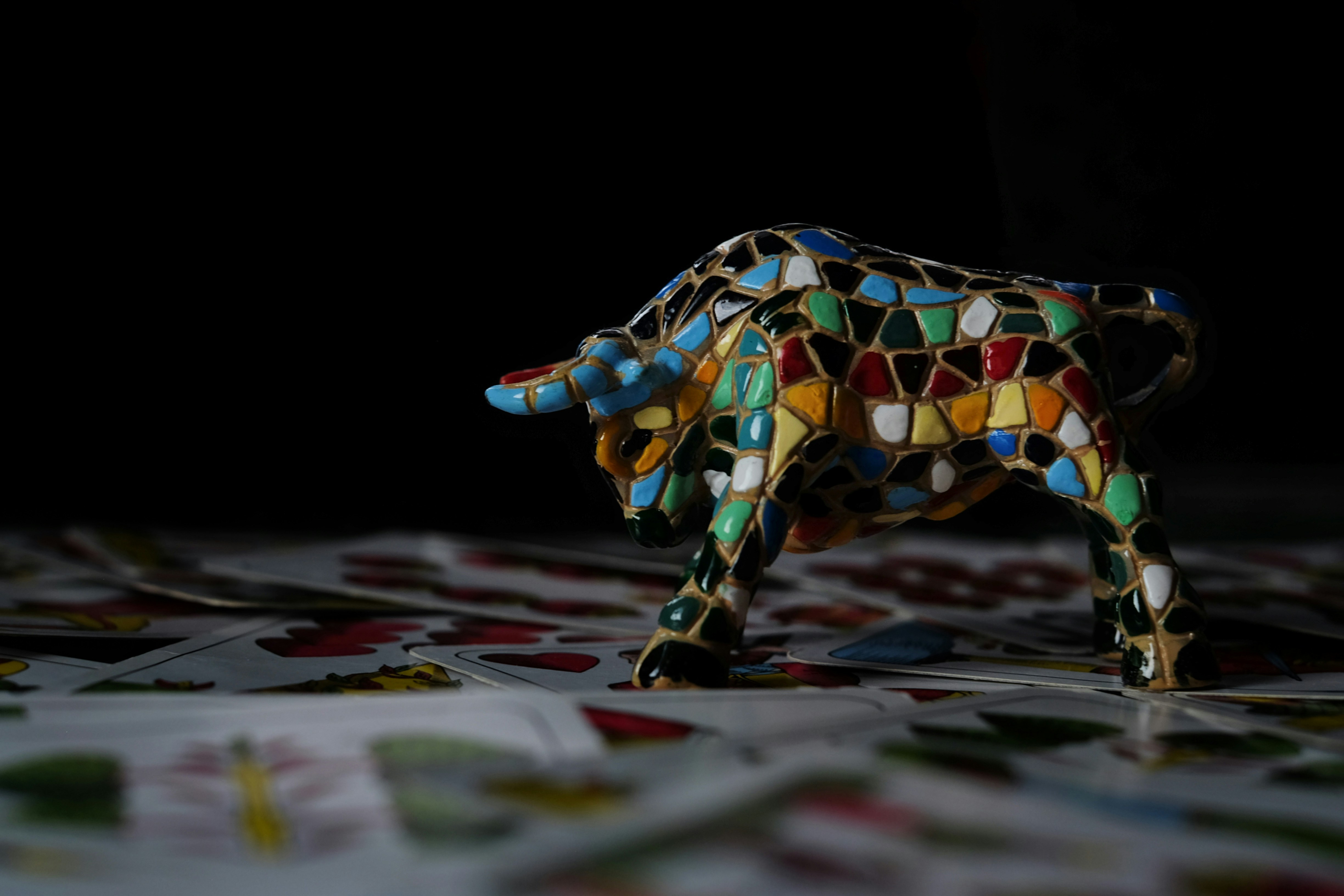 A mosaic bull figurine on a patterned surface.
