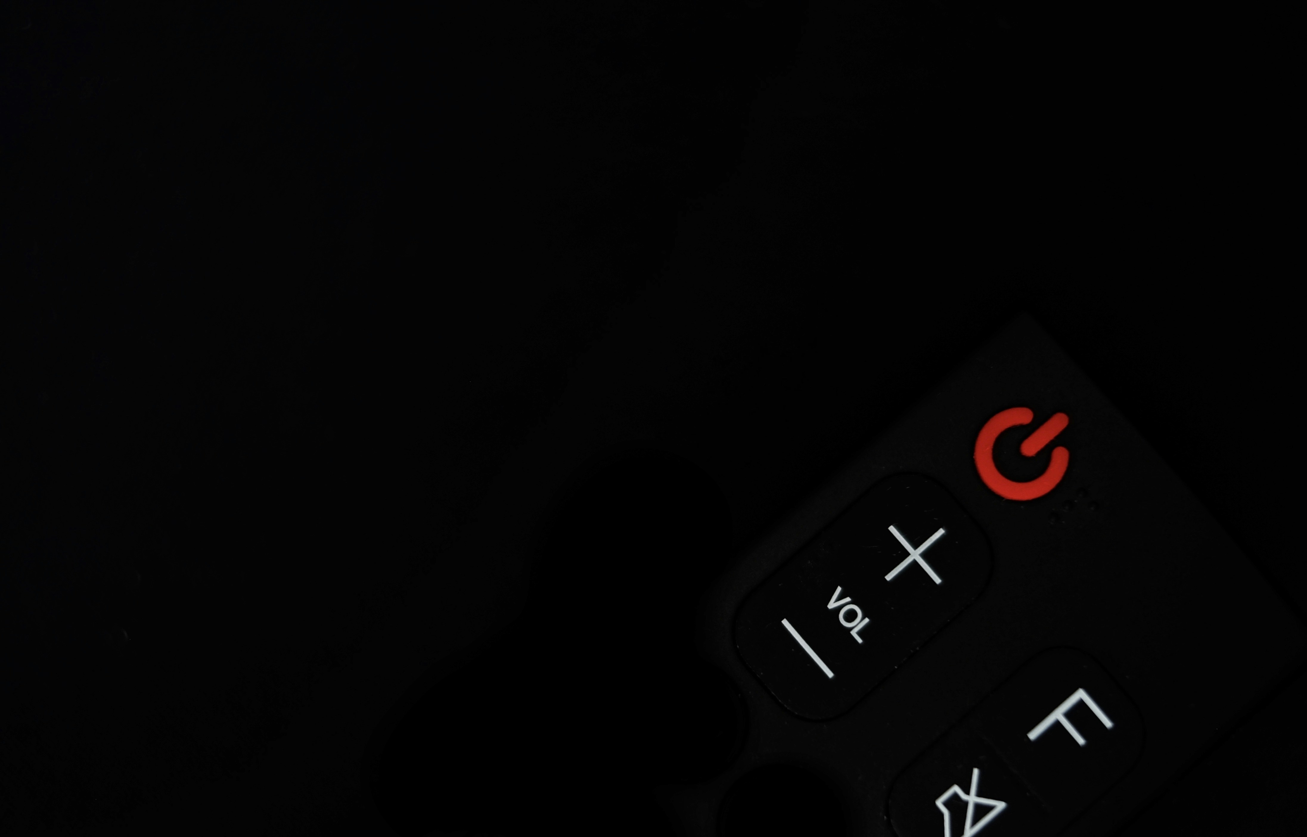Red power button on a black remote control.