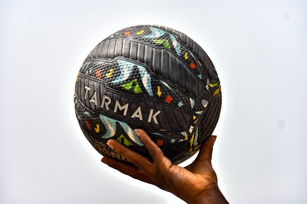 a hand holding a soccer ball with the word tarmak on it
