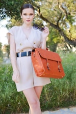 woman in brown dress with brown leather sling bag