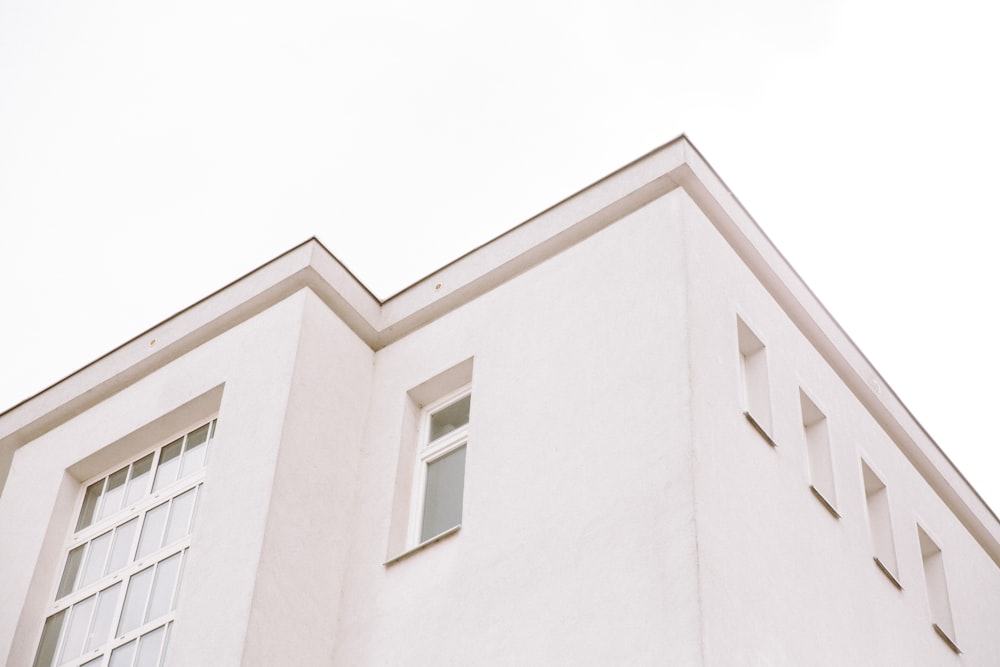 edificio in cemento bianco sotto il cielo bianco durante il giorno