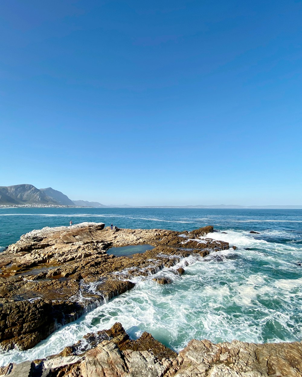 brown rocky shore under blue sky during daytime