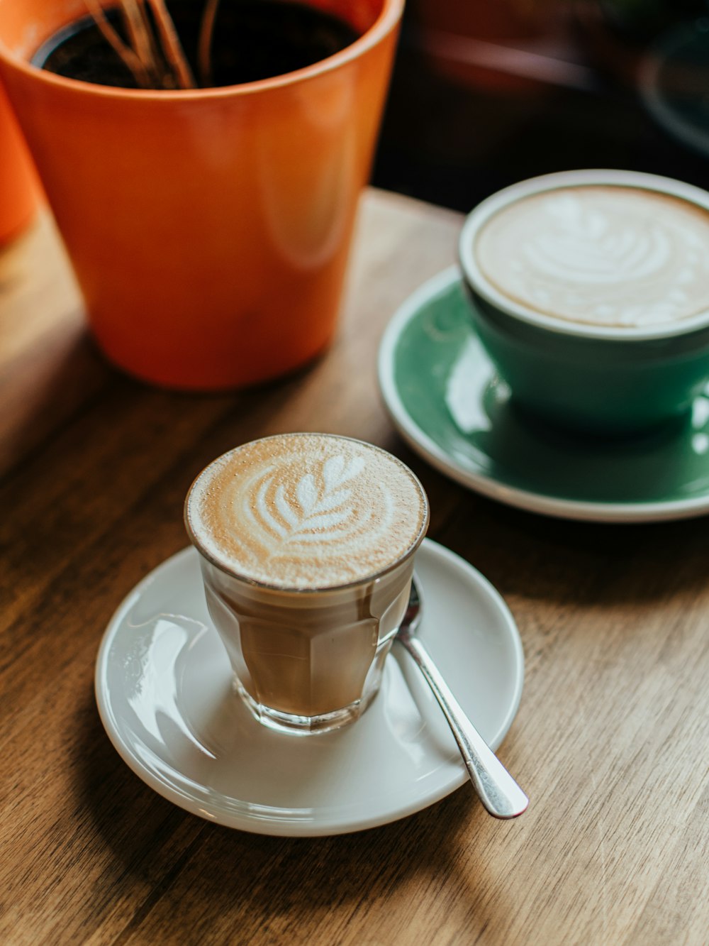 Tasse en céramique blanche et bleue avec soucoupe sur table en bois brun