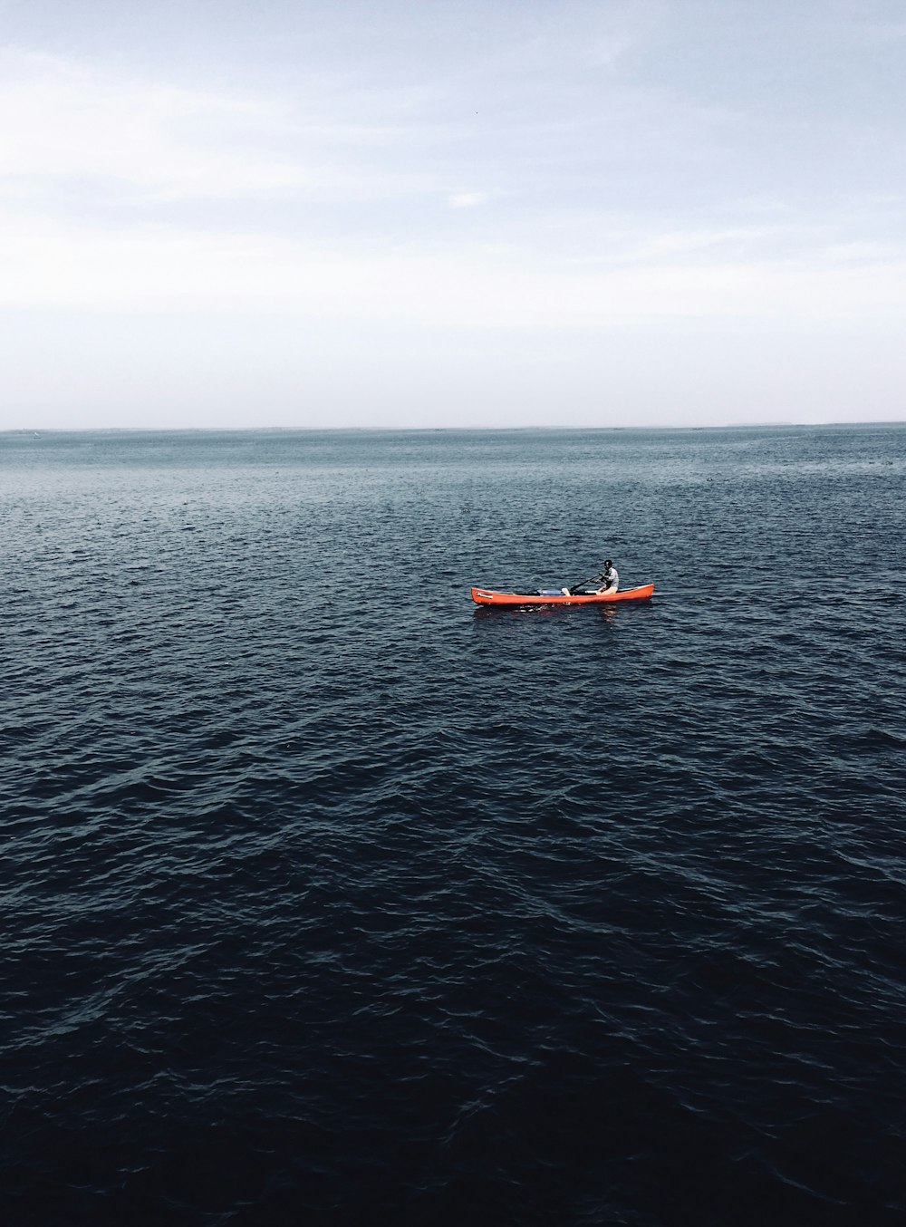 orange boat on blue sea during daytime