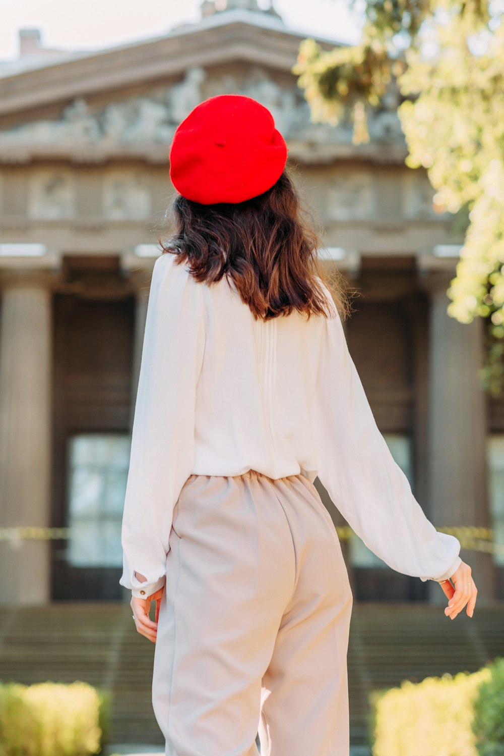 woman in white long sleeve shirt and red knit cap standing