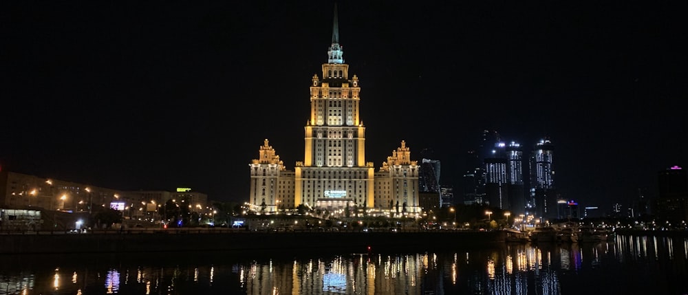 brown concrete building near body of water during night time