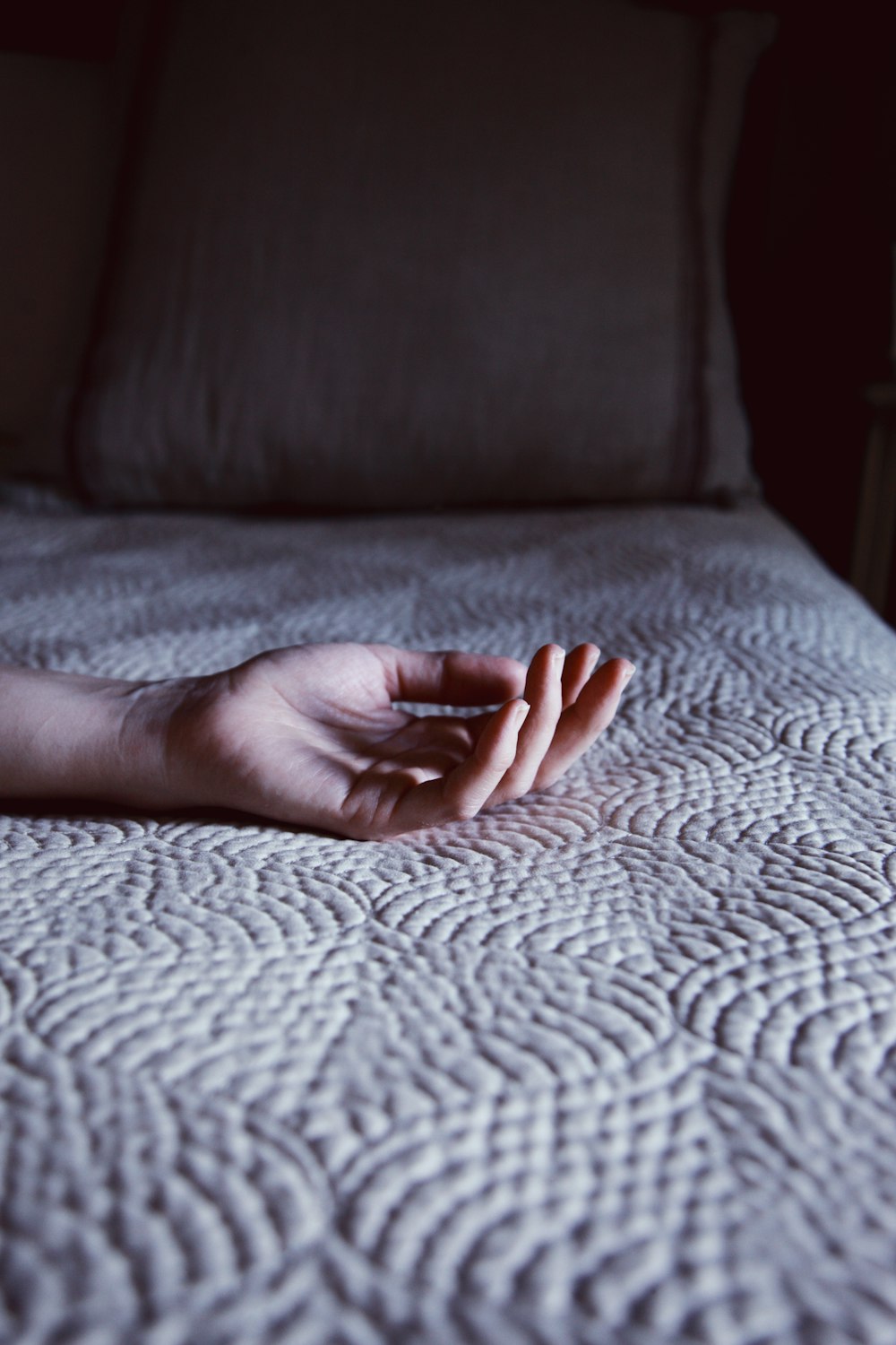 persons hand on white textile