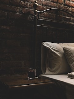 Close-up of a bed bug trap placed discreetly under a bed frame in a cozy bedroom.