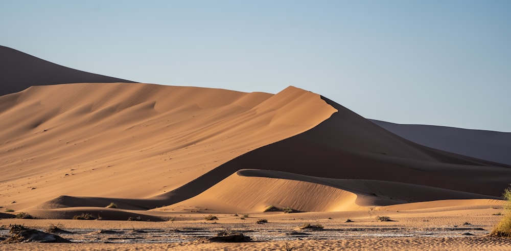 brown sand dunes under blue sky during daytime