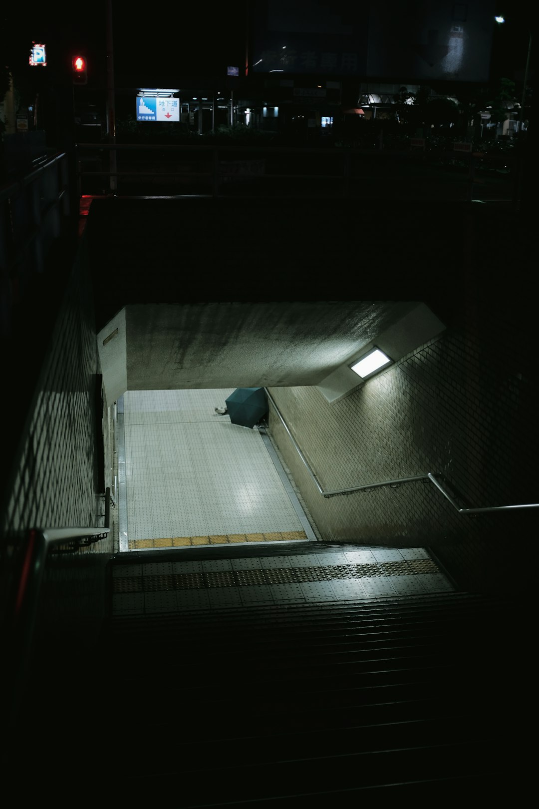 person in blue jacket walking on tunnel