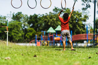 boy in red t-shirt and blue shorts playing basketball during daytime